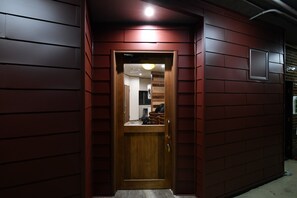 Eine Holztür mit einem kleinen Fenster darüber, eingebaut in eine Wand mit rotem Zierfeld.