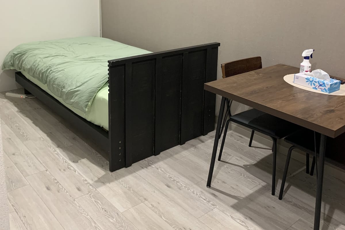 A room with a bed, a table, and a chair.