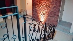 Un escalier avec une rampe en métal et un mur à texture derrière.