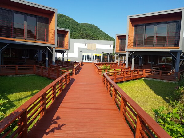 A modern building with a central open area and wooden walkways. - Road 31 Pension (Gyeongju)