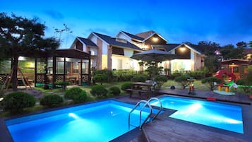 Una piscina al aire libre de temporada, sombrillas