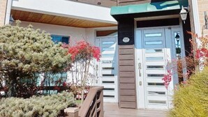 A two-story house with a balcony, a front door, and a staircase leading to the entrance. - Gyeongju Orsay Pension (Gyeongju)