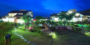 A residential area with houses, a swing set, and a garden path. - Gyeongju Orsay Pension (Gyeongju)