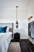 A bedroom with a bed, a nightstand, a wardrobe, and a hanging lantern.