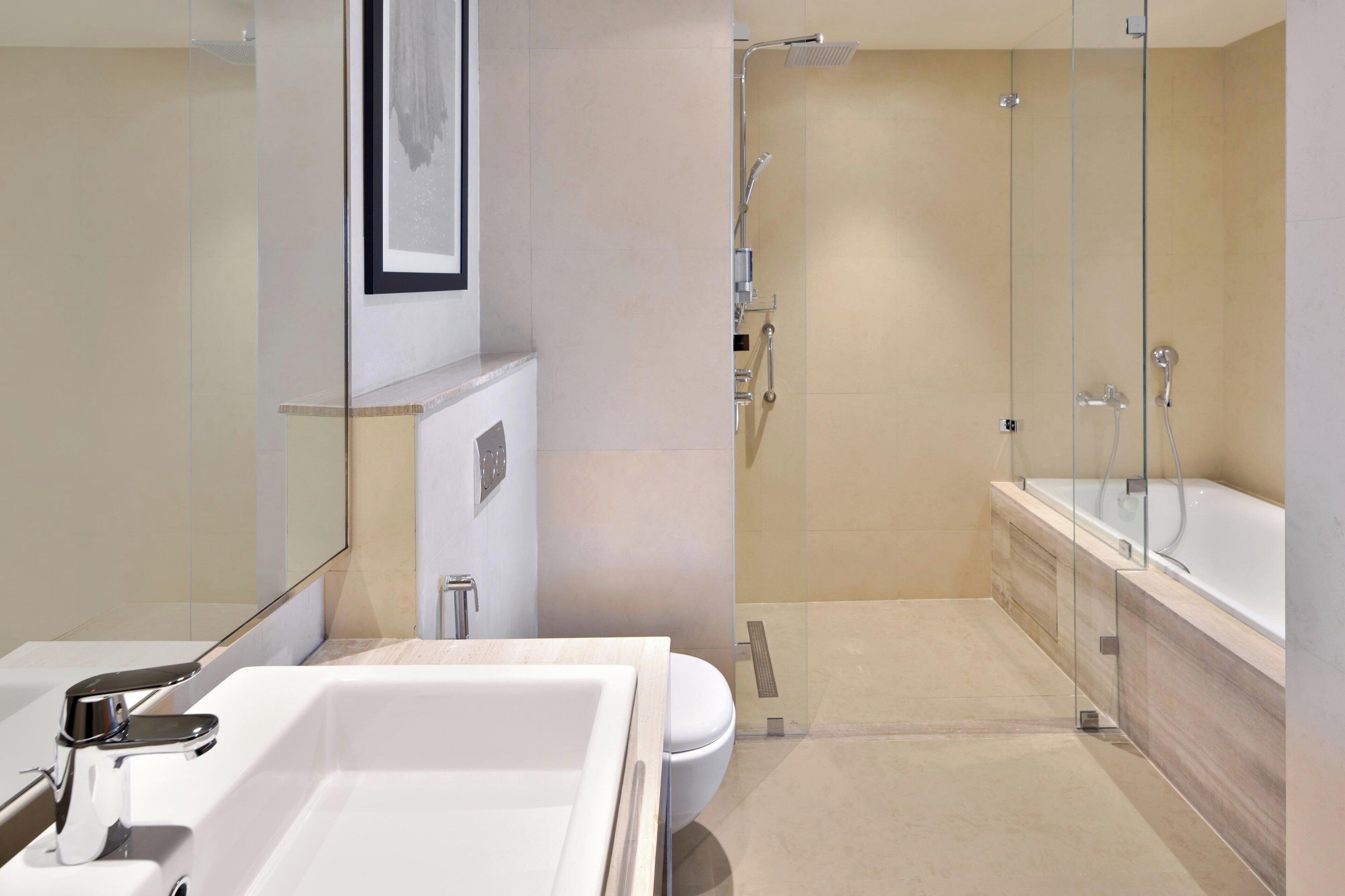 A modern bathroom with a large bathtub, a separate shower area, and a toilet.