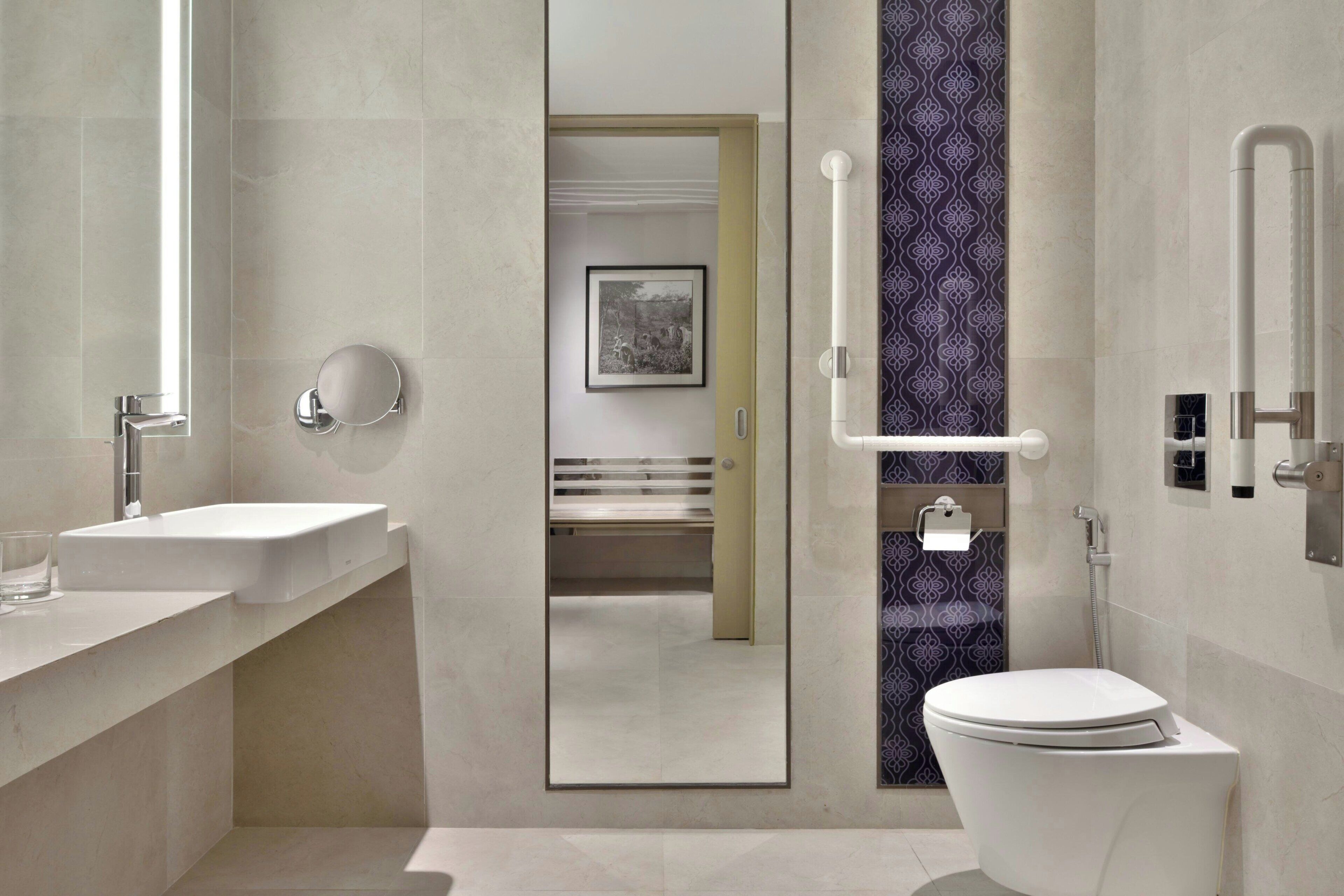 Un baño moderno con lavamanos, inodoro y ducha.