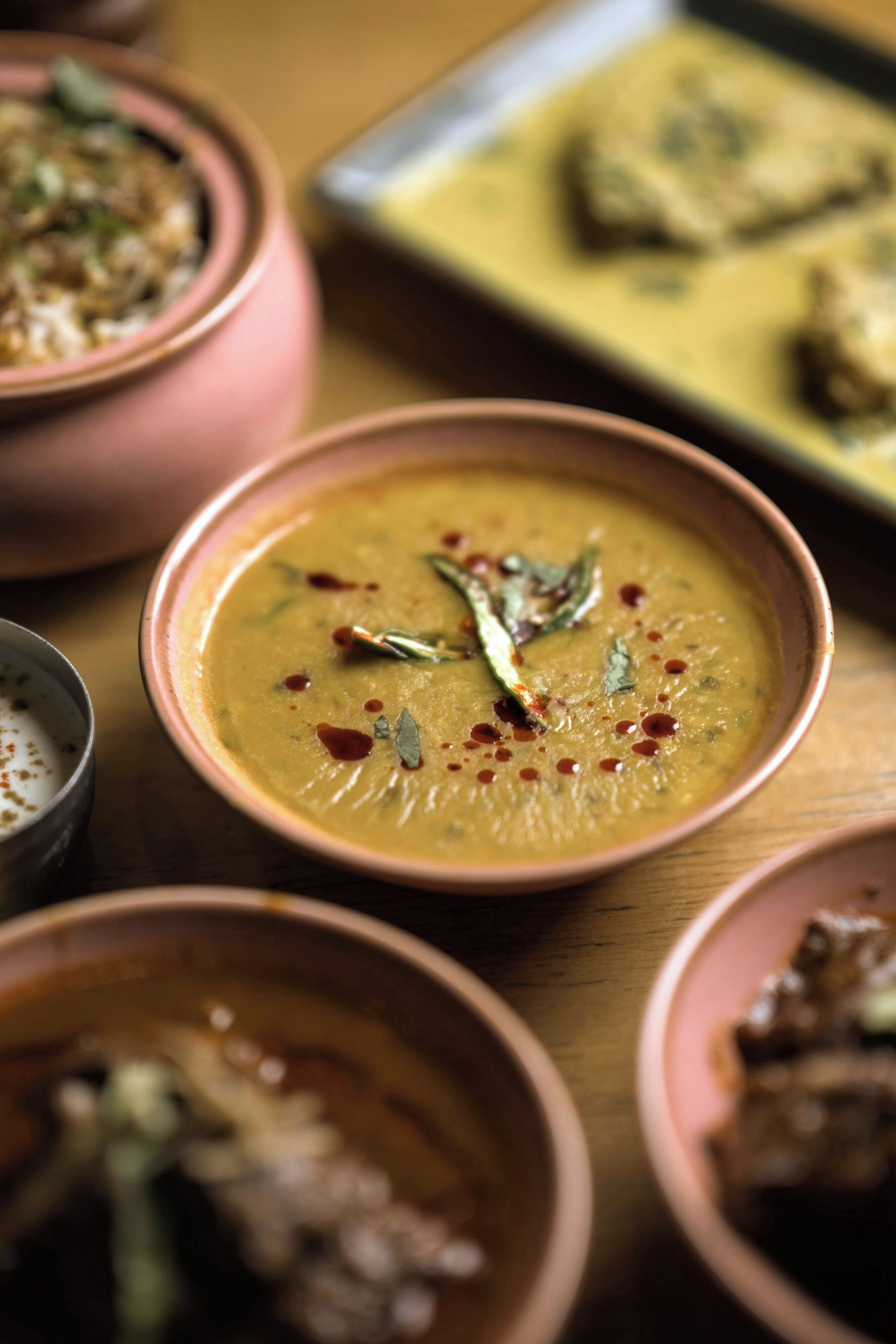 A variety of dishes in different bowls on a wooden table.