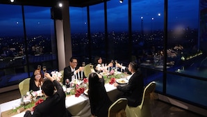 A high-rise dining area with a city view, large windows, and a table set for a group meal. - The Zuri Pekanbaru (Pekanbaru)