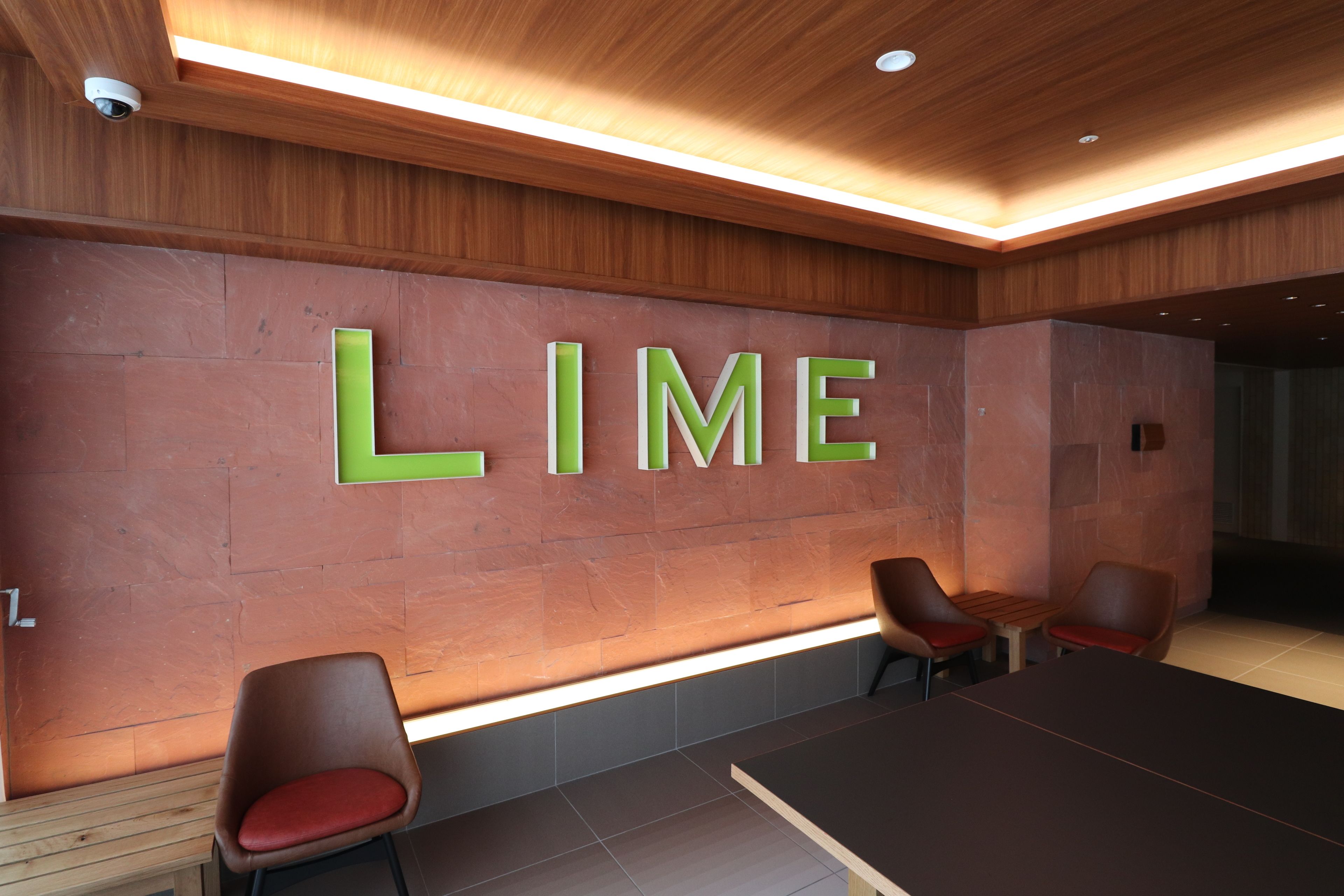 A conference room with a large table and four chairs. The word "LIME" is prominently displayed on the wall.