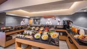 A modern buffet setup with various food stations and chefs preparing meals. - Lime Resort Myoko (Myoko)