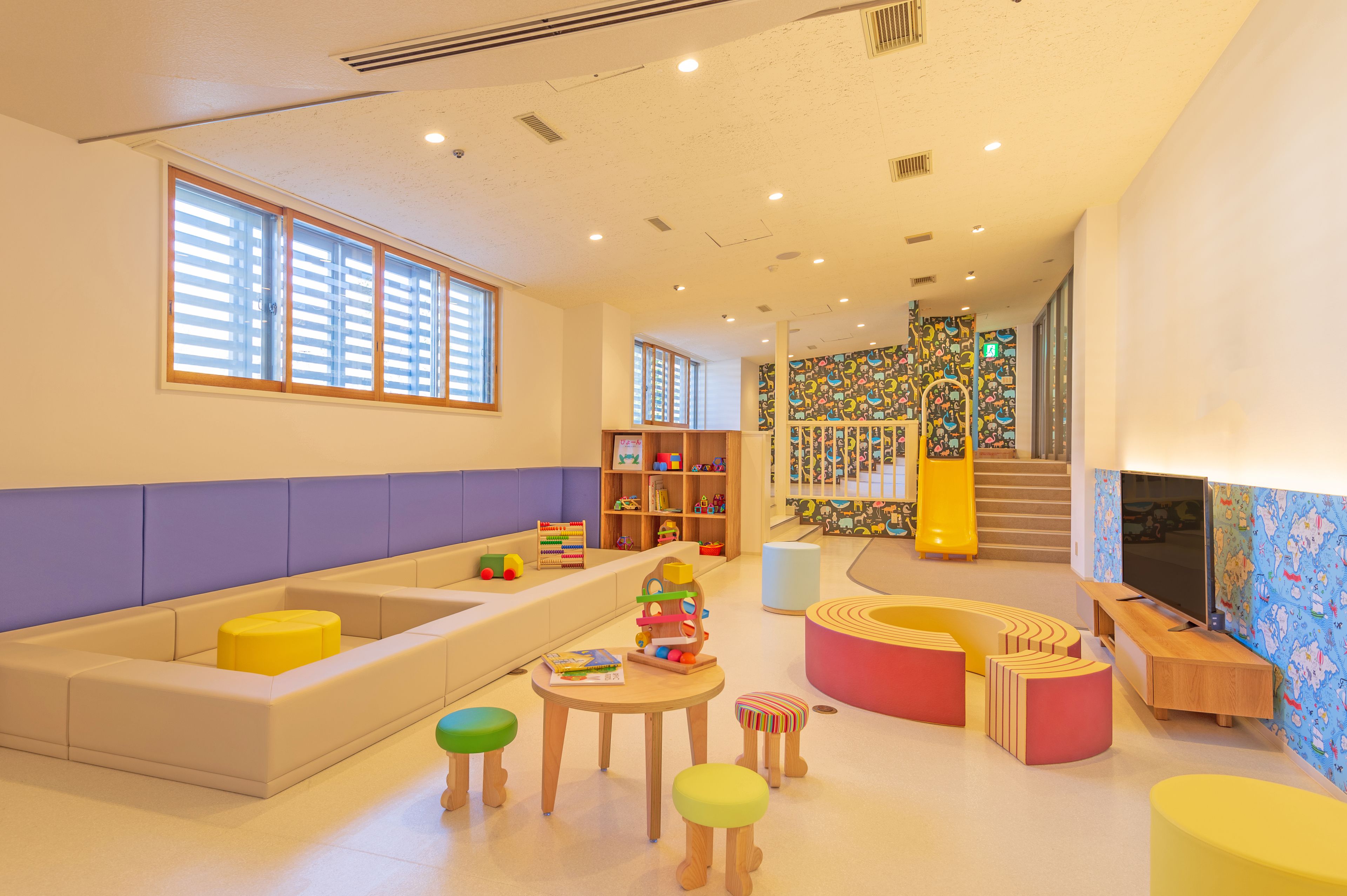 A children's play area with seating, tables, and colorful play structures.