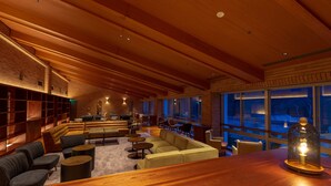 A spacious lounge area with wooden beams, comfortable seating, and large windows. - Lime Resort Myoko (Myoko)
