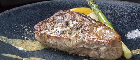 A steak with asparagus and lemon on a plate.
