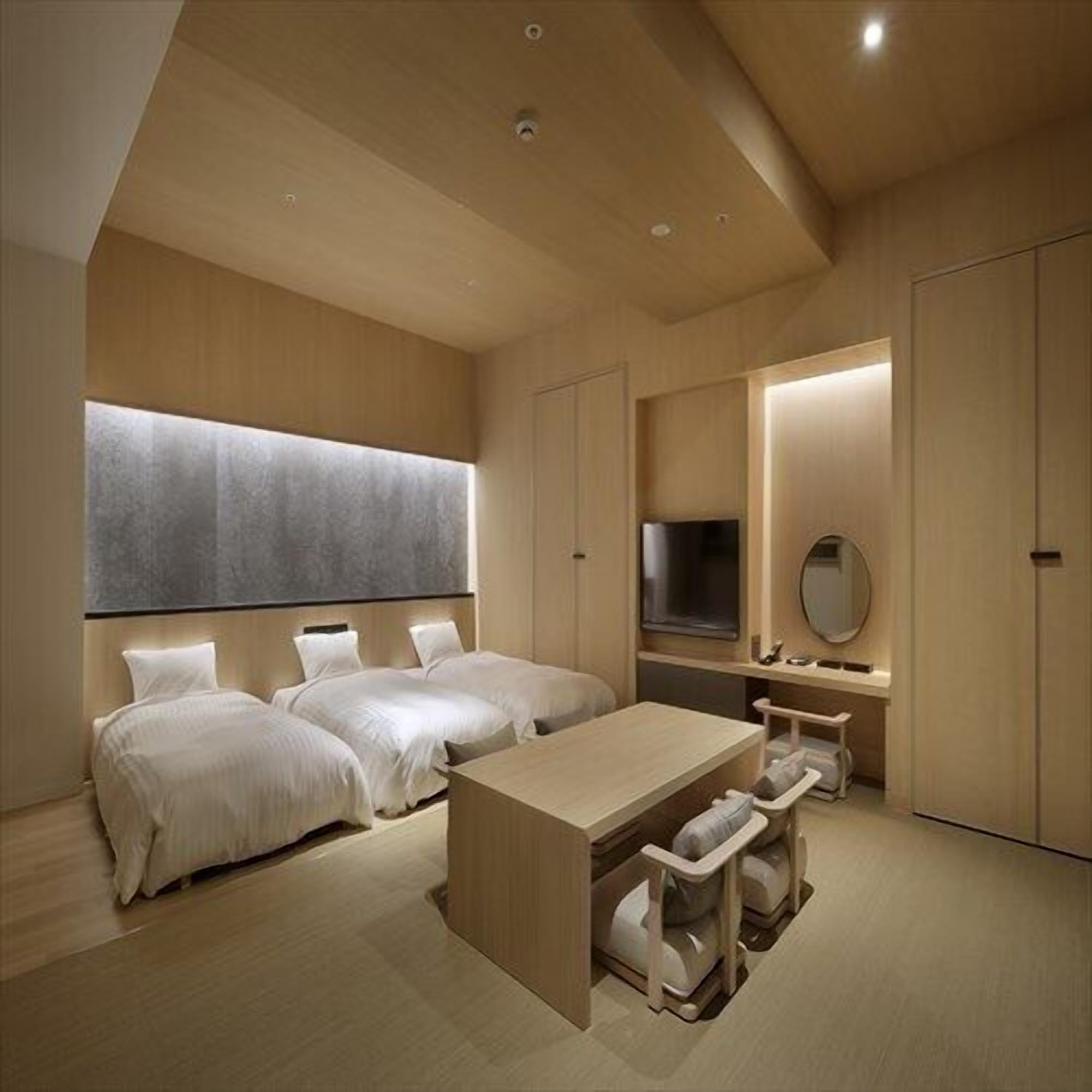 A modern hotel room with a large bed, a desk, and a TV.