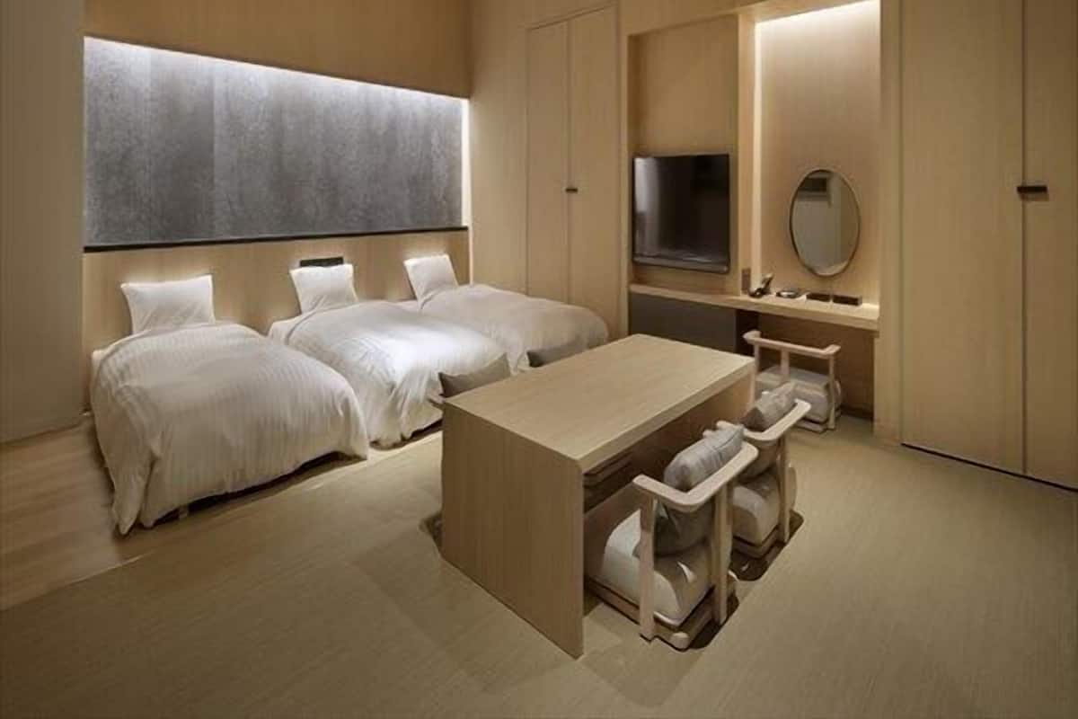 Ein modernes Hotelzimmer mit einem großen Bett, einem Schreibtisch und einem Fernseher.