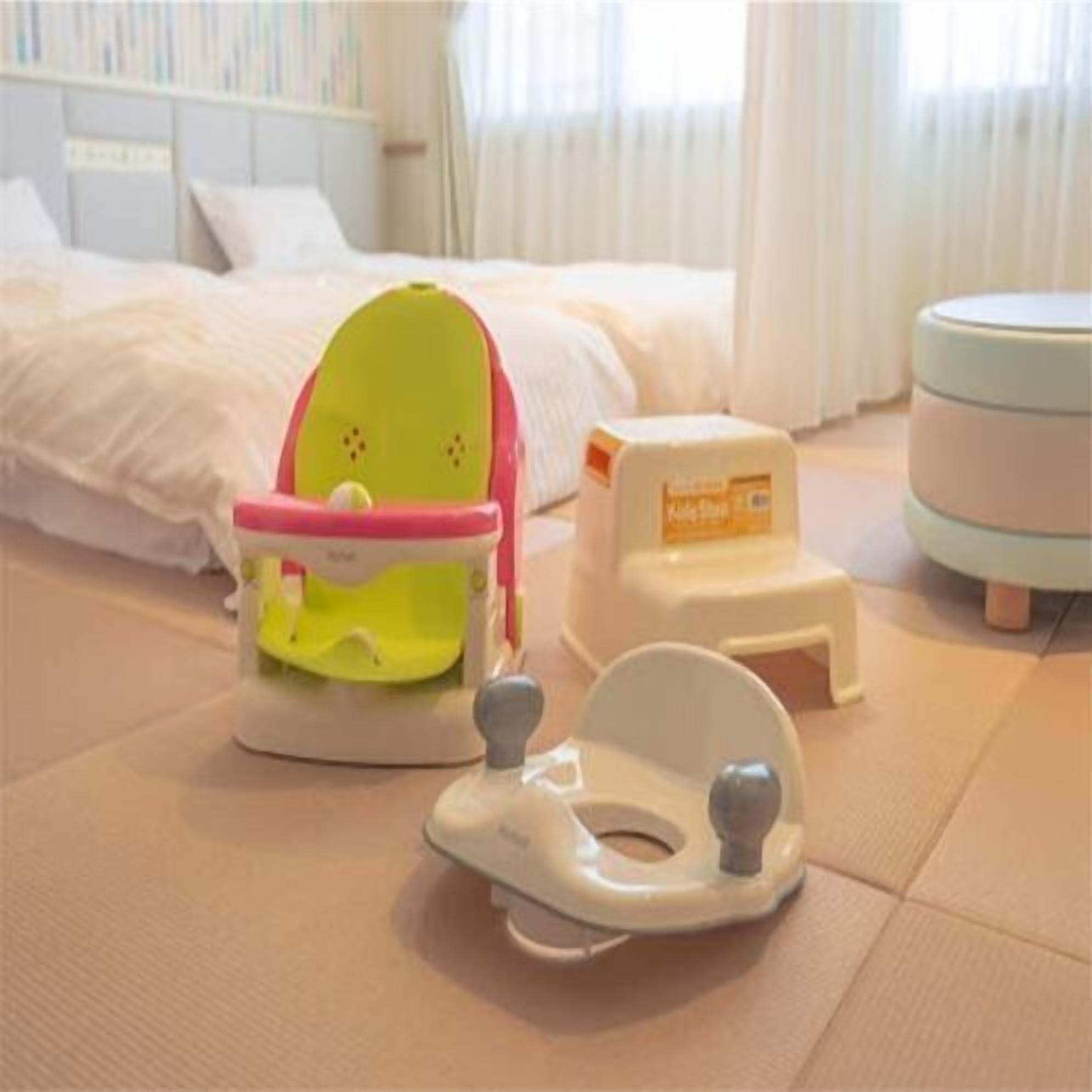 A room with a bed, a small table, and a baby walker.