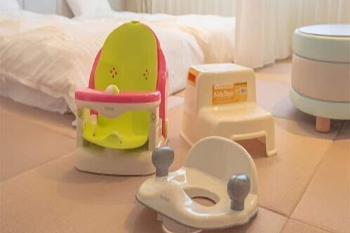 A room with a bed, a small table, and a baby walker.