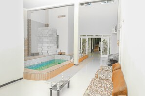 Una sala de estar moderna con un jacuzzi integrado, un sofá y una mesa de centro.