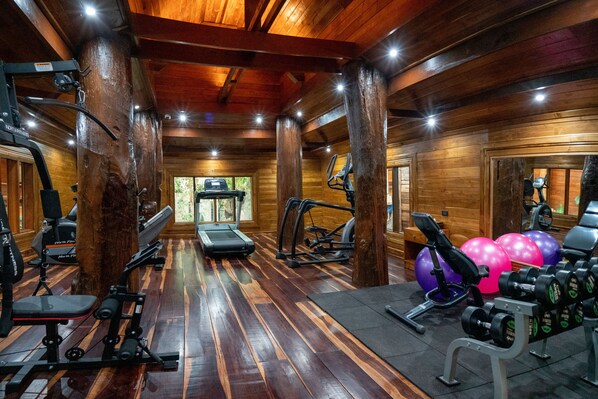 A gym with wooden floors, exercise equipment, and a treadmill. - WandaVista Resort Khum Wang Nuea Chiang Mai (San Kamphaeng)