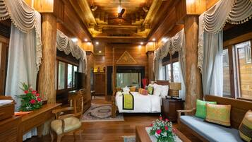 A wooden interior with a bed, sofa, and desk area.