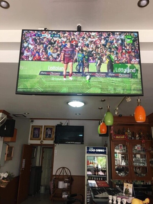 Un téléviseur fixé au plafond diffusant un événement sportif.