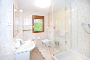 A modern bathroom with a bathtub, toilet, and sink. - Apartment Straßbourg - Europapark (Offenburg)