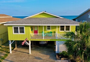 A two-story house with a balcony, a garage, and a small porch area.