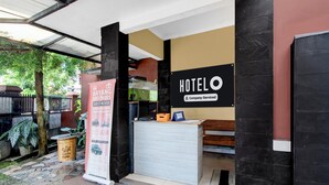 A hotel reception desk with a sign indicating it's a company-serviced establishment. - Hotel O near UGM formerly Bayang Brothers Guest House (Depok)