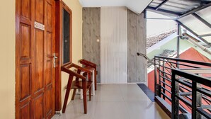 A balcony with a wooden door labeled '206', a metal railing, and a view of a red building. - Hotel O near UGM formerly Bayang Brothers Guest House (Depok)
