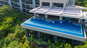 A modern building with a rooftop pool and lush greenery around it. - Glamday Style Hotel & Resort Okinawa Yomitan (Yomitan)