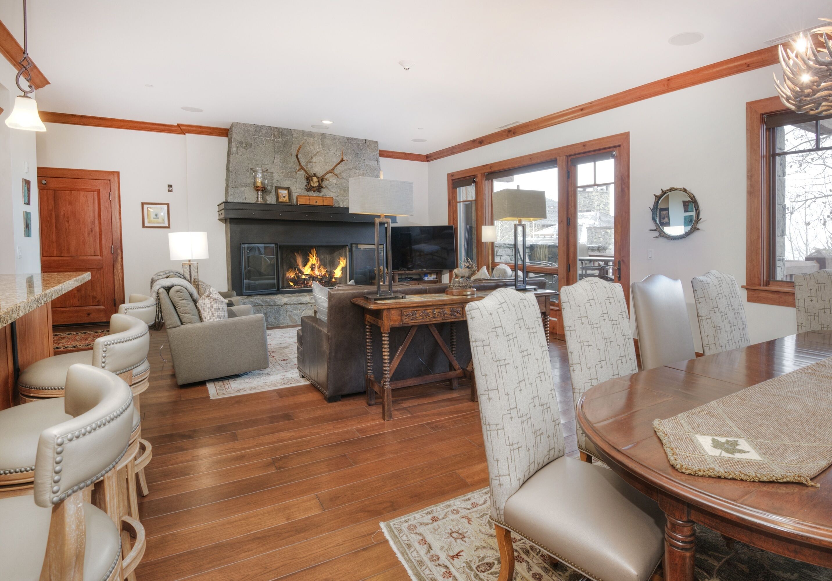 A cozy living room with a fireplace, comfortable seating, and a dining area.