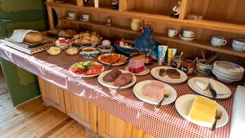 Una mesa de buffet con distintos alimentos y utensilios.