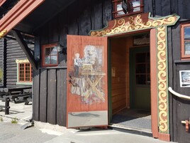 Un edificio de madera con una puerta grande y ornamentada y un cartel que dice "1938".