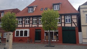 Un bâtiment traditionnel à colombages, avec un toit recouvert de tuiles rouges, une porte verte et une enseigne indiquant « RÄTSKELLER ».