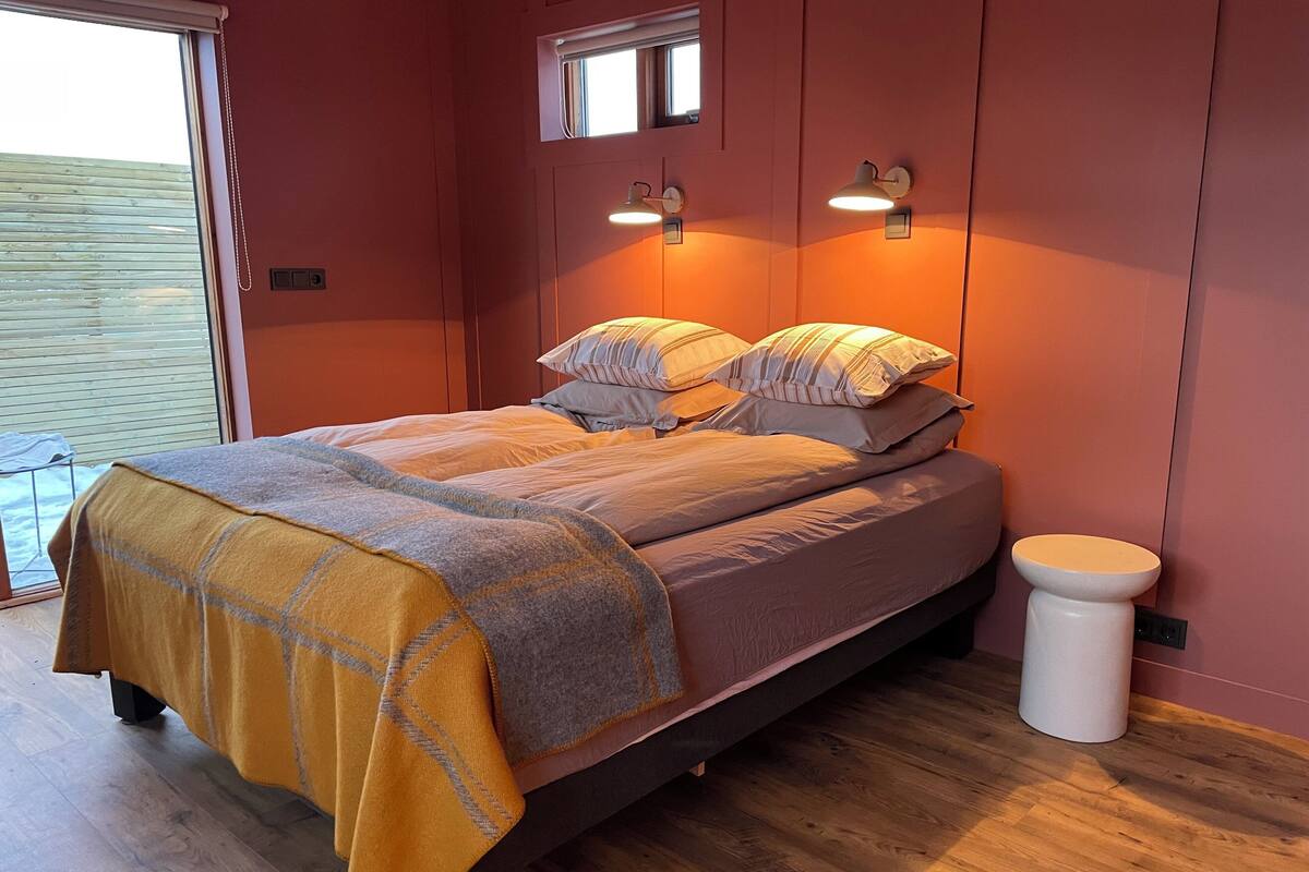 Une chambre à coucher avec un lit, une table de chevet et une fenêtre.