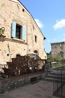 Un edificio de piedra con una reja de metal decorada con numerosos candados.