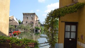 A courtyard with a water feature, a stone bridge, and a historic building in the background. - Le Finestre su Borghetto (Valeggio sul Mincio)