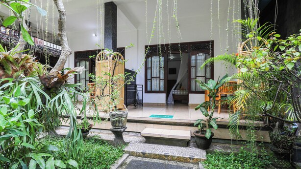 Un bâtiment de style traditionnel, doté d’un porche, de plantes en pot et d’un escalier menant à l’étage supérieur.