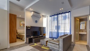 Una sala de estar moderna con sofá, televisor y mueble de entretenimiento.