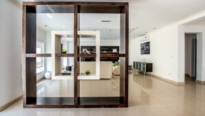 Un interno moderno con una parete divisoria in legno, una zona living con divano e un'area pranzo con tavolo e sedie.