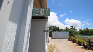 Un edificio con una terraza de madera y un letrero con el número 201.