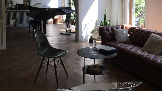 A spacious living room with a piano, a leather sofa, a dining table, and a modern chandelier. - Liberté (Marseille)