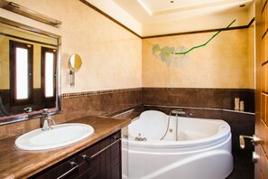 A bathroom with a sink, mirror, and bathtub. - Grand Villa Santorini (Santorini)