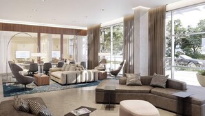 A modern hotel lobby with a large seating area, a reception desk, and large windows offering a view of the outside. - AC Hotel by Marriott San Jose Santa Clara (Santa Clara)