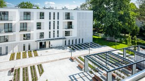 A modern multi-story building with a flat roof, large windows, and a central entrance. - Apartments with Event Space & Hot Tub (Kraków)