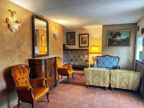A traditional living room with a fireplace, a large mirror, and classic furniture. - Collis Petri Relais (Collepietro)