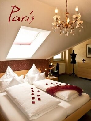 A hotel room with a bed, a chandelier, a desk, and a wardrobe. - Hotel 4 Winden (Windhagen)