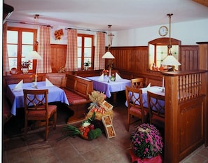 Una posada tradicional con muebles de madera, varias mesas de comedor y bancos.