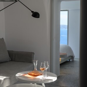 Echoes Suite with private outdoor heated plunge pool- semi outdoor hot tub and Caldera View | Living area | 32-inch flat-screen TV with satellite channels, TV, Netflix - Echoes Luxury Suites (Santorini)