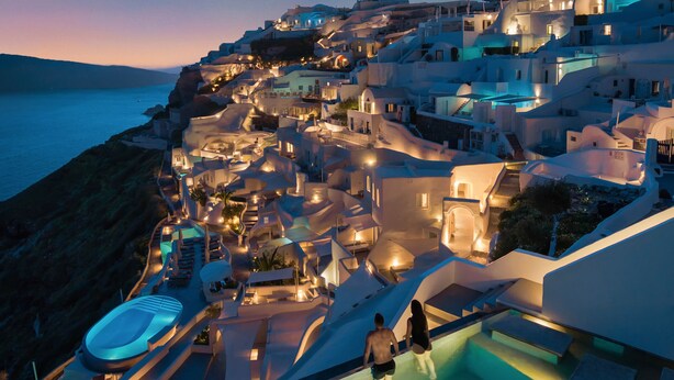 A coastal hotel with a swimming pool, a beach, and a view of the sea. - Echoes Luxury Suites (Santorini)